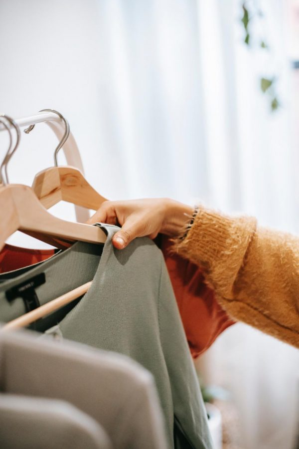 Stock photo of hand decisively choosing shirt or sweater from closet. 