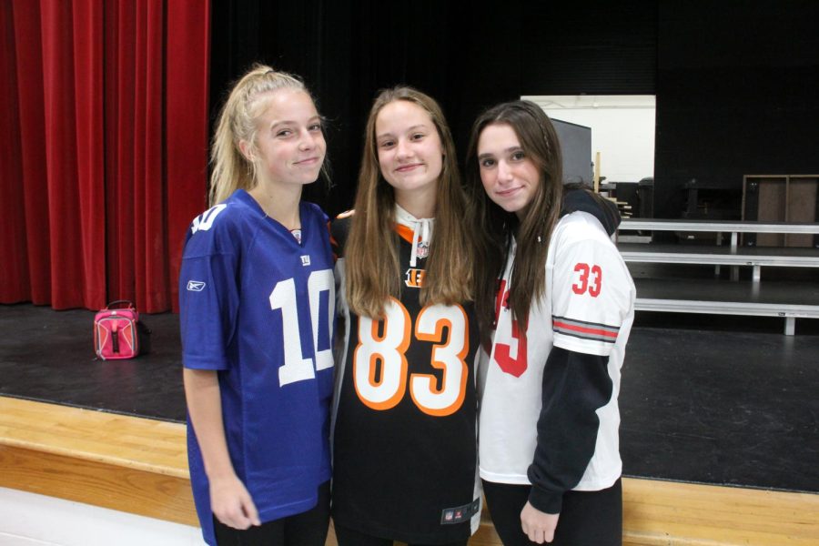 Juniors Carmela Dixon and Mattie Shoemaker, alongside sophomore Lilly Turbovitch (left to right) sporting various football jerseys.
