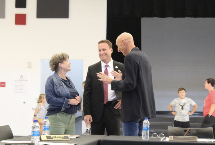 Dr. Miller speaks with board members Christine Blacka and Steve Votaw at the September board meeting.