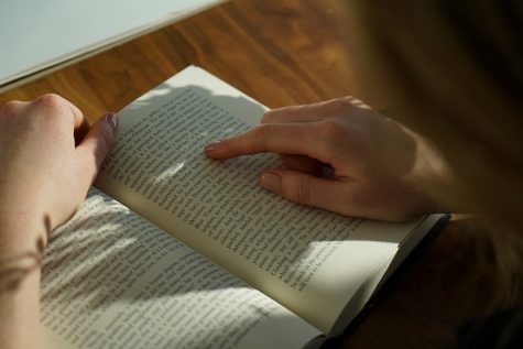 Student reads a book. Reading material for your course as well as for enjoyment can help you balance studying and relaxation during your stressful week.