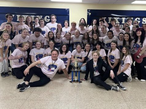 Show choir poses with trophy.