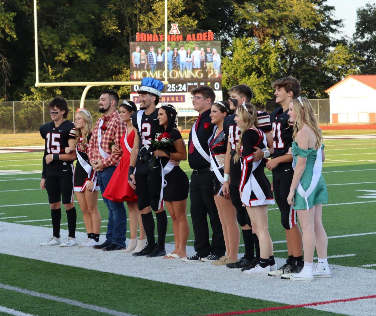 The 2023-2024 Homecoming court lines up on the sideline together. 