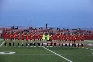 JAHS Girls Soccer team lines up for the national anthem on home field.