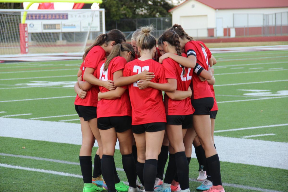 The girls team huddles together before the game.