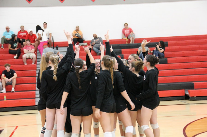 Volleyball team cheers before game starts. 