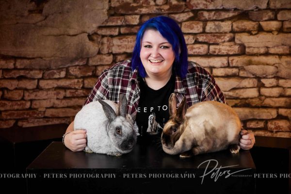 Addie Wilkin poses with her show rabbits in her senior photo.