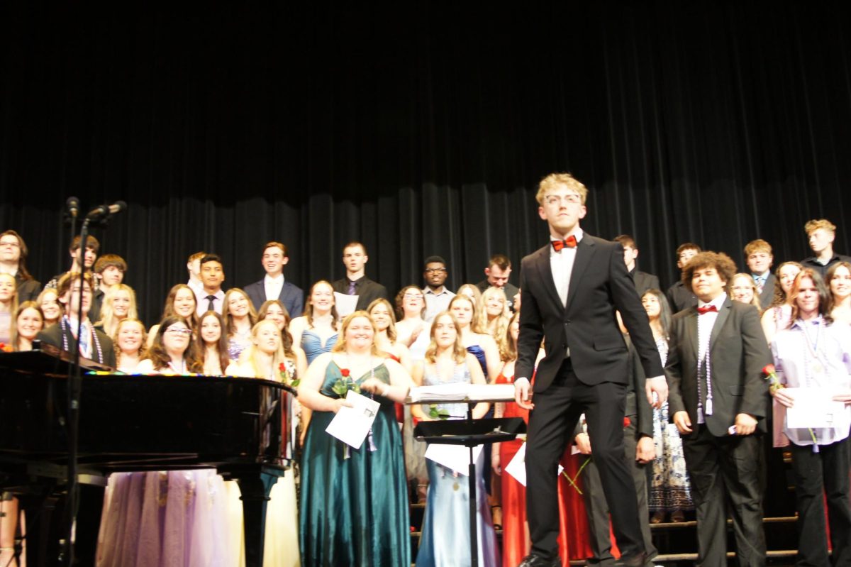 Choir teacher Nicholas Mayes steps onto the podium to direct the combined choirs' final piece.