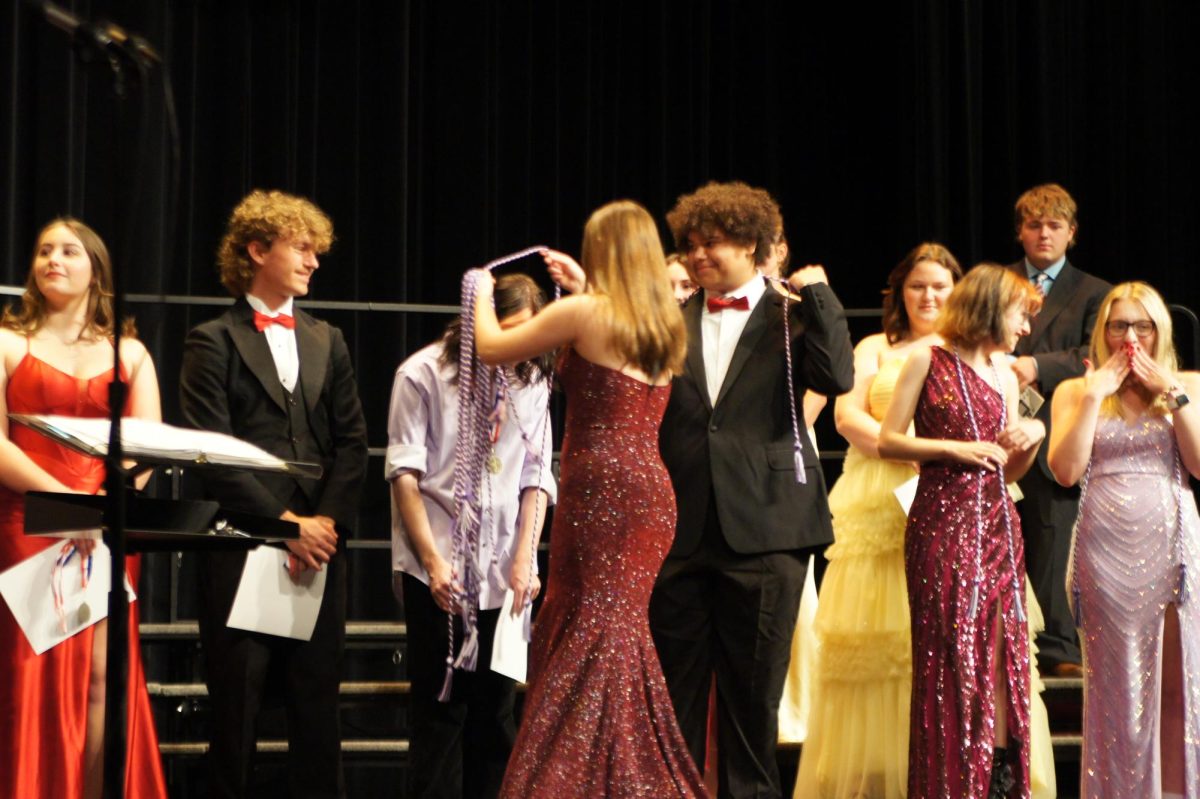 Tyson awards senior Gavin Hawkins with his choir cord.