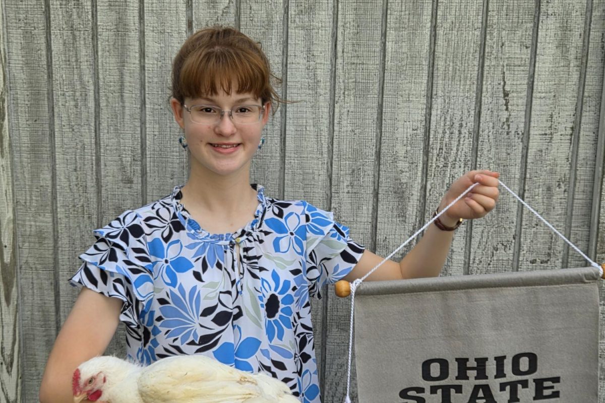 Michaela Eades poses with one of her chickens.