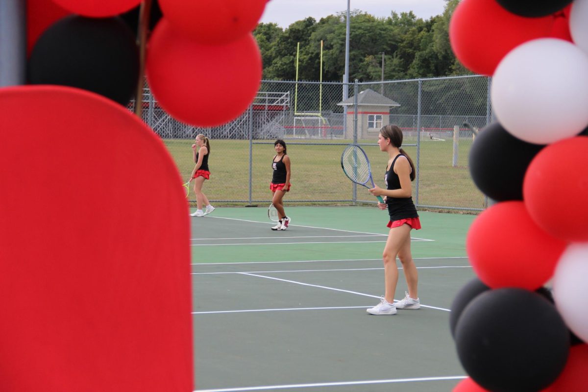 (From left to right) Manring, Flores-Villanueva, and senior Kenlee Thomas warm up.