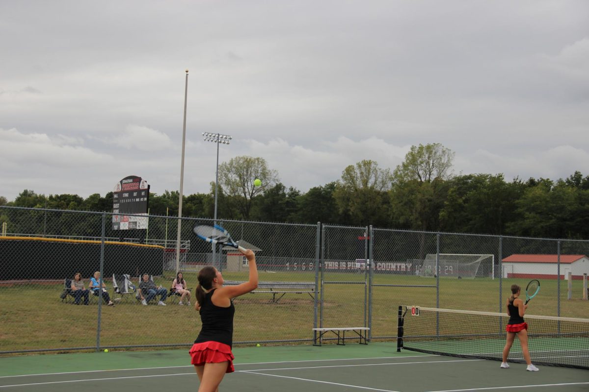 Senior Ashlyn serves in a doubles practice with her partner senior Gabby Elias.