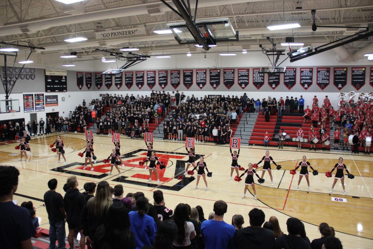 Cheerleaders hold up Alder letter signs.