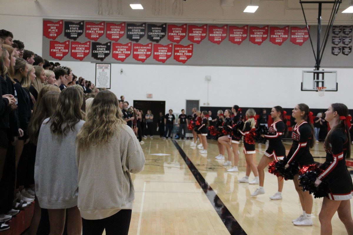 Cheerleaders lead the freshman in a cheer.