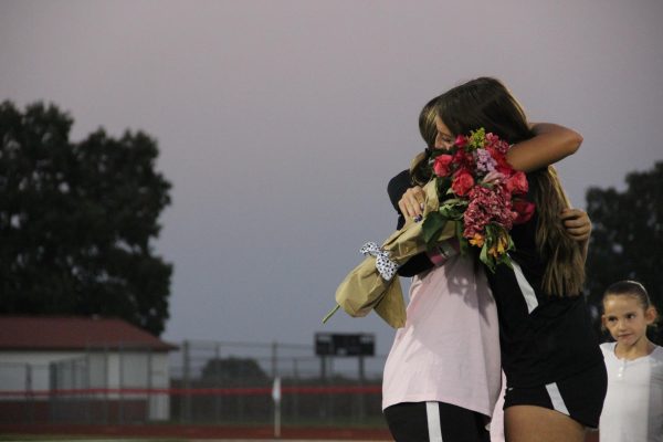 Senior captain Caroline Timberlake receives flowers for Senior Night from Junior Lily Hilbert.
