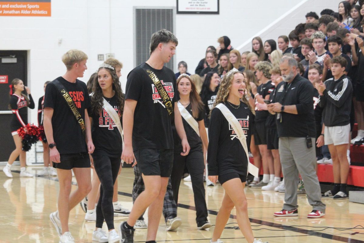 Senior homecoming court members exit after being announced.