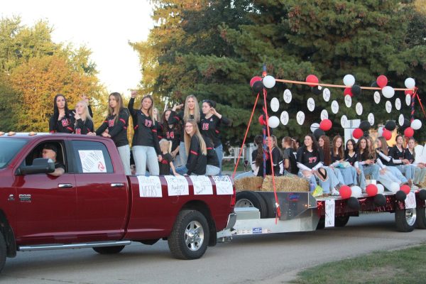 The varsity volleyball team throws candy to parade watchers