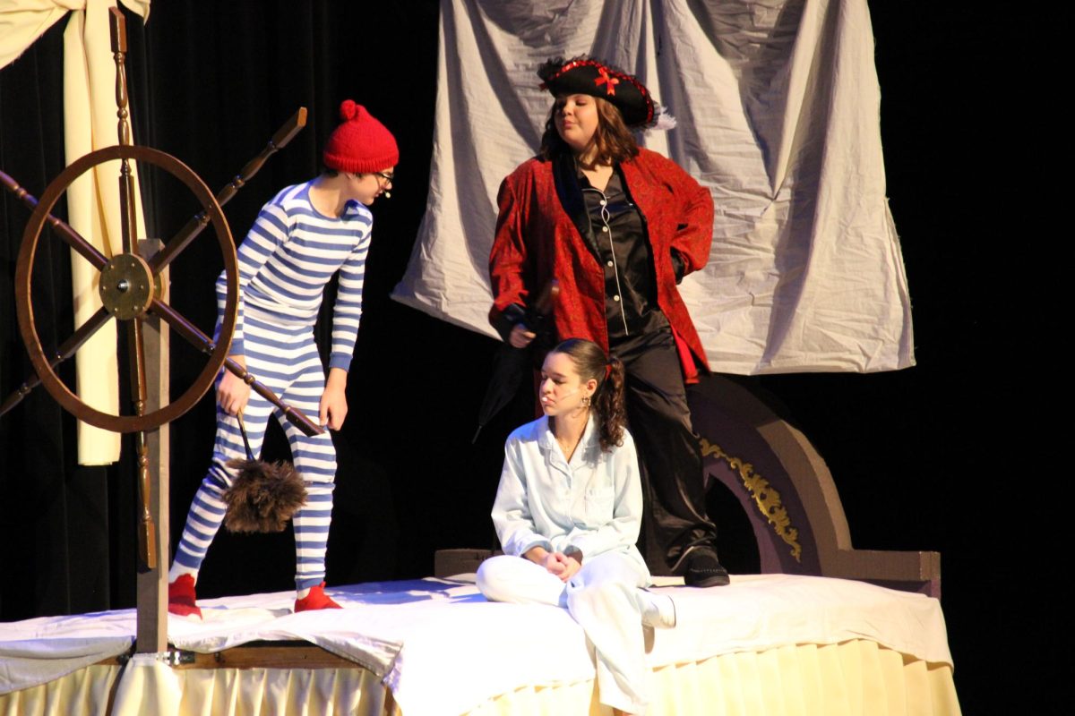 Mr. Smee (freshman Kegen Wolf) and Captain Hook (sophomore Makenzie Karasek) threaten Wendy (McCabe).