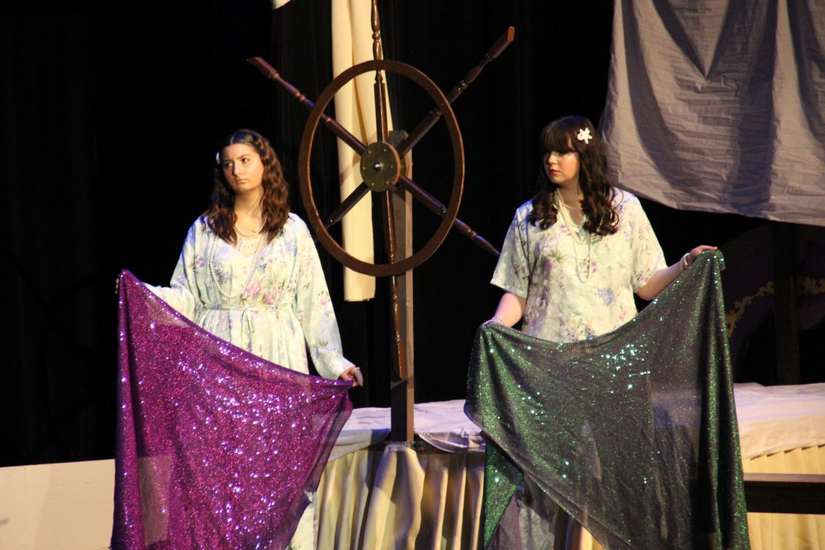 The mermaids (sophomores Ruthie Sebestyen and Caroline Kerr) watch the action.