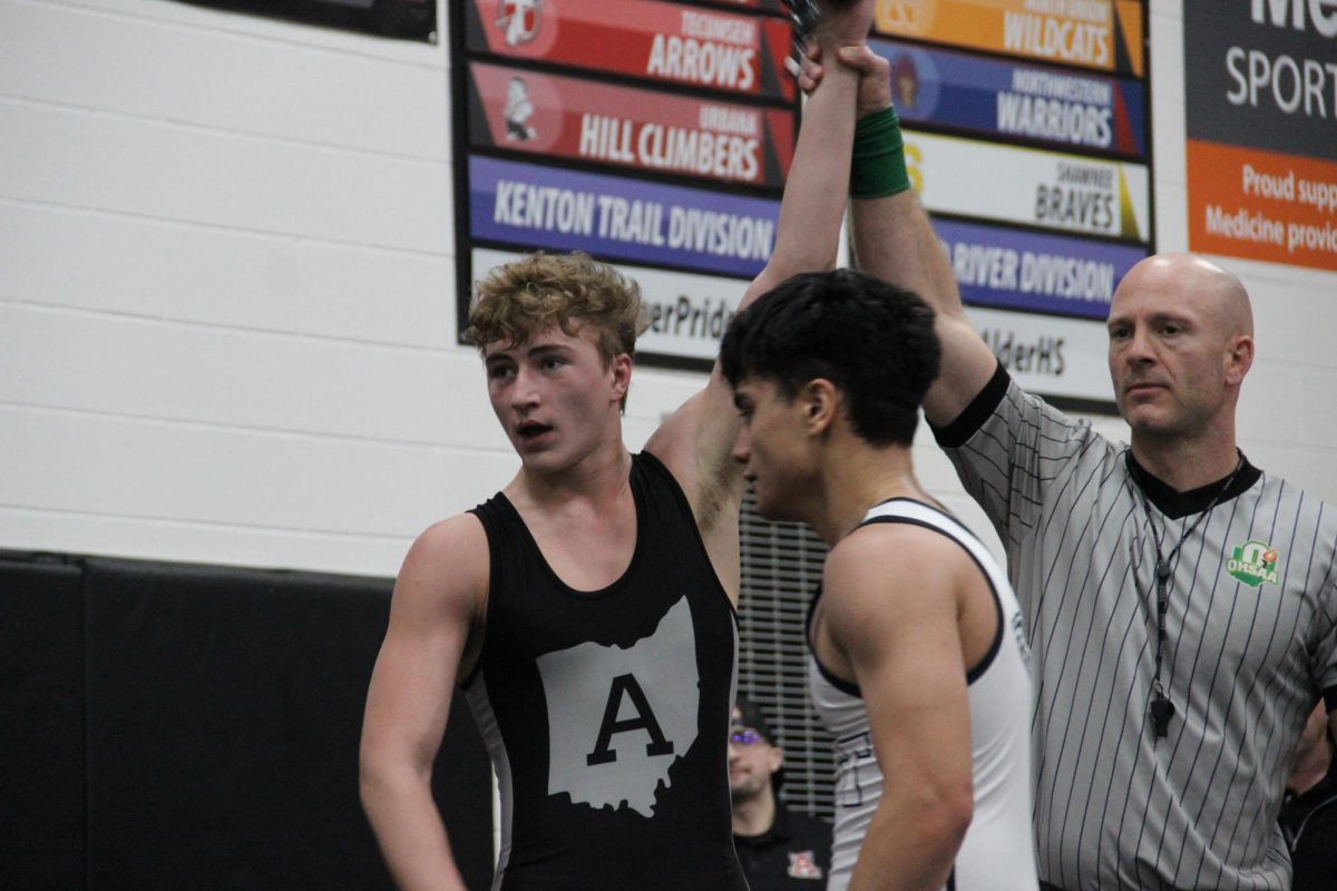 Senior Aiden Ricker gets his hand raised after a win. 