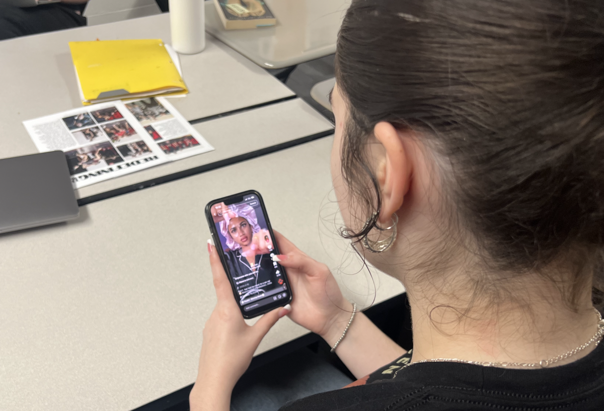 Student watches the TikTok morning shed trend on their phone